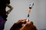 A syringe is prepared with the Pfizer COVID-19 vaccine at a vaccination clinic at the Keystone First Wellness Center in Chester, Pa., Dec. 15, 2021.