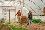 Audrey Barbour, left, and Kelly Sauskojus, right, check out the greenhouse at Battlefield Farm in Knoxville, Tenn., a community garden and alternative congregation started by Pastor Chris Battle.