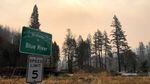 A roadside sign welcomes people to Blue River, Oregon, as smoke fills the skies from the 2020 Holiday Farm fire.