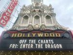 The Hollywood Theatre's historic marquee reads OFF THE CHARTS, advertising the night's event. It also reads FRI: ENTER THE DRAGON underneath.