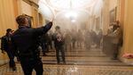 In this Jan. 6, 2021, file photo, smoke fills the walkway outside the Senate Chamber as rioters are confronted by U.S. Capitol Police officers inside the Capitol in Washington.