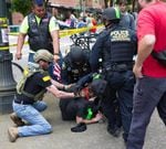 A member of the Oath Keepers helps police officers detain a protester during the dueling rallies in Portland, Oregon, June 4, 2017.