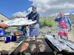 Paul Myrick helps cover salmon filets in foil. While not the traditional way to cook salmon, it helps the fish cook faster.