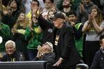 FILE: Oregon fan and Nike co-founder Phil Knight, center, acknowledges the crowd during the first half of an NCAA college basketball game between Oregon and Colorado in Eugene, Ore., Thursday, Feb. 13, 2020. 