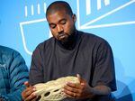 Ye, then known as Kanye West, holds a Yeezy sneaker while speaking onstage at the Fast Company Innovation Festival in 2019.