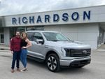 Nick Schmidt poses with his wife after picking up his brand new electric F-150. Schmidt was the first buyer to get the F-150 Lightning as auto makers are betting billions in an electric future.