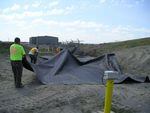 Contractors place an engineered cover, called geomembrane, over the balefill area at Pasco Sanitary Landfill. The fire under this area burned for about two years. Photo credit: John Richards