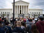 A line of pro-life demonstrators watch as Pro-choice demonstrators chant in front of an un-scalable fence that stands around the U.S. Supreme Court in Washington, DC, on Thursday.