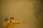 FILE - Firefighters give directions during the Beachie Creek Fire near Gates, Ore., Sept. 9, 2020.
