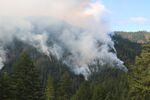Smoke rises from the Rum Creek wildfire, seen from Graves Creek.