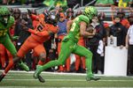 Oregon running back Travis Dye (26) gets past Oregon State defensive back Alex Austin (5) and heads to the end zone during the first quarter of an NCAA college football game Saturday, Nov. 27, 2021, in Eugene, Ore.