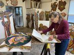 Betty LaDuke hojea algunos de sus muchos cuadernos de bocetos en su estudio.