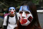 Two people wear masks while attending a protest in Myanmar.