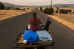 Rylee Buckley, 17, drives home in an ATV loaded with two, 7-gallon containers after borrowing water for her animals from a neighbor, Saturday, July 24, 2021, in Klamath Falls, Ore. The Buckley's house well ran dry in May following a historic drought in Southern Oregon. 