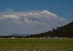 A smoke column shown over a pasture illustrates the vastness of the Bootleg Fire in Oregon.