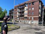 A fire official points to structural fire damage on the outside of an apartment building
