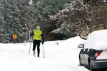 A skier heads down a residential street where about six inches of snow fell overnight Thursday, Jan. 6, 2022, in Bellingham, Wash. The latest storm to hit the Pacific Northwest brought flood warnings, the shutdown of a major mountain pass, school closures and icy roads.