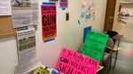 Signs on walls and taped to chairs say things like "If you really care about gun violence, sign here."