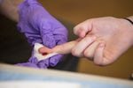 Jeff Strang of the Multnomah County Health Department draws blood from ACCESS Academy 8th grader Maura Kelley to test for lead.