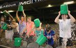 Participants tip buckets of ice water over their heads as they take part in the World Record Ice Bucket Challenge at Etihad Stadium on Aug. 22, 2014, in Melbourne, Australia.