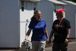 Longview City Councilor Ruth Kendall, left, strolls through Hope Village on May 12, 2023, with case worker Hollie Hillman in Longview, Wash. The new shelter has been a divisive topic and continues to get support.