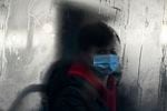 A commuter masks up for a bus ride in Liverpool. The omicron variant has surged in the U.K. — and is now dominant in the U.S. as well. There's now data indicating just how severe the symptoms might be.