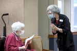 Resident Janice Biggerstaff, 91, left, talks with Kathy Watson, director of health services at Friendsview Retirement Community in Newberg, Ore., during a COVID-19 vaccination clinic on Feb. 5, 2021. Biggerstaff was thrilled to receive a vaccine, saying "I have stayed in my apartment. I don't go anywhere. I would like to have some freedom. I would like to hug my grandchildren."