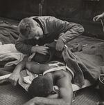 Victor Jorgensen (American, 1914-1994), Untitled (Corpsman checks wounds) from 1945.