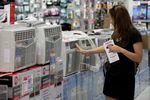 FILE: A woman looks at air conditioners for sale in a P.C. Richard & Son store, in New York,  Sunday, July 1, 2012.