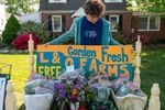 Leal Abbatiello, 14, inspects the display of produce before community members come at their home in Alexandria, Va. on April 30, 2022.