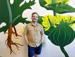 Founding distiller Seth O’Malley stands in front of a botanical mural at the Wilderton Distillery and Tasting Room in Hood River, Ore. on August 2, 2023.