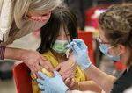 Kelly Leung, 11, is reassured by Multnomah County health officers as Leung receives vaccinations at a catch-up vaccination clinic in 2023. Oregon is resuming eligibility checks for people on Medicaid which includes about half of Oregon's children. Starting this year, they can stay enrolled until their 6th birthday.
