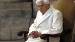 Pope Benedict XVI, wearing all white, sits in a chair.