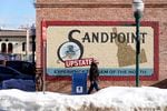 A pedestrian walks past a mural, Monday, Feb. 7, 2022, in downtown Sandpoint, Idaho. The Mayor of Sandpoint and many residents worry that the trend of a growing number of real estate companies advertising to conservatives that they can help people move out of liberal bastions like Seattle and San Francisco and find homes in places like rural Idaho is not good for their community.