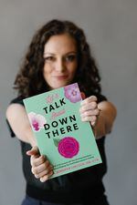 A person holds out a book with the title "Let's talk about down there"