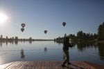 A man does tai chi as hot air balloons lift off over the lake at Big Summit Prairie in Central Oregon.