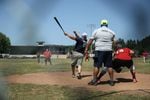 A player smacks a softball toward right field during a slow-pitch tournament at the Friendship Jamboree in Vernonia, Ore., Saturday, Aug. 3, 2019, the Greenman Field grandstands in the background. Activists see the Friendship Jamboree as a key event in the future of the grandstands.