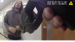 A hand holding a stun-gun is pointing toward the lower body of a man in a sweatshirt.