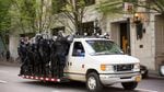 Police dressed in riot gear mobilize to follow a group of counter-protesters marching north on Portland's Southwest 4th Avenue. Police eventually pinned the marching crowd in, where they detained dozens of people, including several journalists.