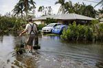 A resident walks back home on a flooded street in Fort Myers, Fla., on Sept. 29, 2022, the day after Hurricane Ian slammed into the area.