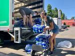 Volunteers and Multnomah County employees unload cases of water to supply a 24-hour cooling center set up in Portland, Ore., Wednesday, Aug. 11, 2021, as a dangerous heat wave grips the Pacific Northwest.