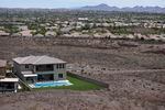 FILE - A home with a swimming pool abuts the desert on the edge of the Las Vegas valley, Wednesday, July 20, 2022, in Henderson, Nev. The U.S. Bureau of Reclamation is expected to publish hydrology projections on Tuesday, Aug. 16, 2022, that will trigger agreed-upon cuts to states that rely on the river.