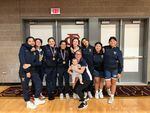 Girls wrestling head coach Jessica Lister holds her infant while posing with the 2022-2023 girls wrestling team at Hood River Valley High School. In April, the Oregon School Activities Association unanimously approved sanctioning girls wrestling as an official high school sport.