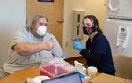 Eric Cox, left, gives a thumbs-up with Multnomah County Public Health Nurse Maren Peters, after Cox received his COVID-19 vaccine, April 1, 2021 at a clinic hosted by Transition Projects' Clark Center Shelter.