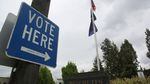 A sign points to a ballot box in downtown Bend, May 19, 2020. 