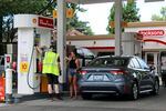 A gas station attendant helps a driver fill up their tank at a gas station in Portland, Ore., Aug. 4, 2023.