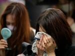 One of people who offer flowers and prayers for former Prime Minister Shinzo Abe, cries at Zojoji temple prior to his funeral wake Tuesday, July 12, 2022, in Tokyo.