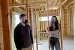 Residential construction students Benjamin and Alyssa standing in the house they're building, designed by a previous student.
