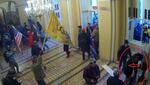 A red circle is drawn on an image with a red arrow pointing at a person inside the circle. The picture also shows a large number of people entering a majestic hallway. Many people carry flags, including the U.S. flag and the yellow "Don't tread on me" Gasden flag.