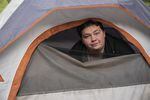 Chris Drake pokes his head out of his tent on a rainy day in North Portland. Drake was camping alongside I-5 before moving into the LGBTQ outdoor emergency shelter in Southeast Portland.